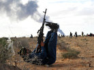 A Libyan rebel fighter uses his legs to steady his weapon as he fires at a fighter jet during clashes with pro-Gadhafi forces outside the oil town of Ras Lanuf. A Libyan rebel fighter uses his legs to steady his weapon as he fires at a fighter jet during clashes with pro-Gadhafi forces outside the oil town of Ras Lanuf.