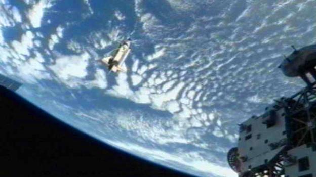 The space shuttle Discovery(C) departs the International Space Station on March 7, 2011.
