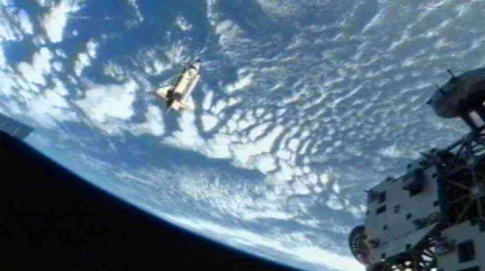 The space shuttle Discovery(C) departs the International Space Station on March 7, 2011.
