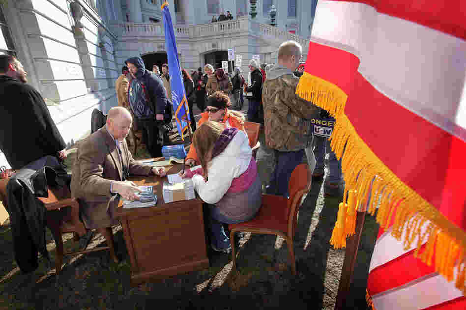 Wisconsin State representative Fred Clark meets with constituents at his desk outside the capitol building March 2, 2011 in Madison. Clark and several other Democrat members of the assembly moved their offices outside as the building has been essentially locked down to prevent protesters from spending the night inside. 