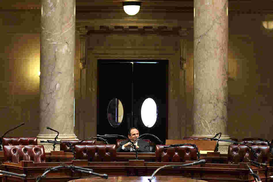 Chairs sit empty during a session of the state Senate at the Wisconsin State Capitol on Wednesday, where resolutions passed unanimously to impose $100-a-day fines on the 14 Senate Democrats who fled the state for each day that they do not show up for Senate sessions.  