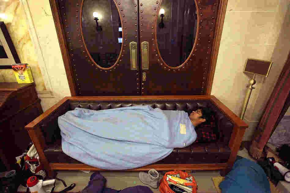 A protester sleeps in front of the doors to the Wisconsin state Assembly chamber, hoping to block access before the session reconvened later in the morning. 