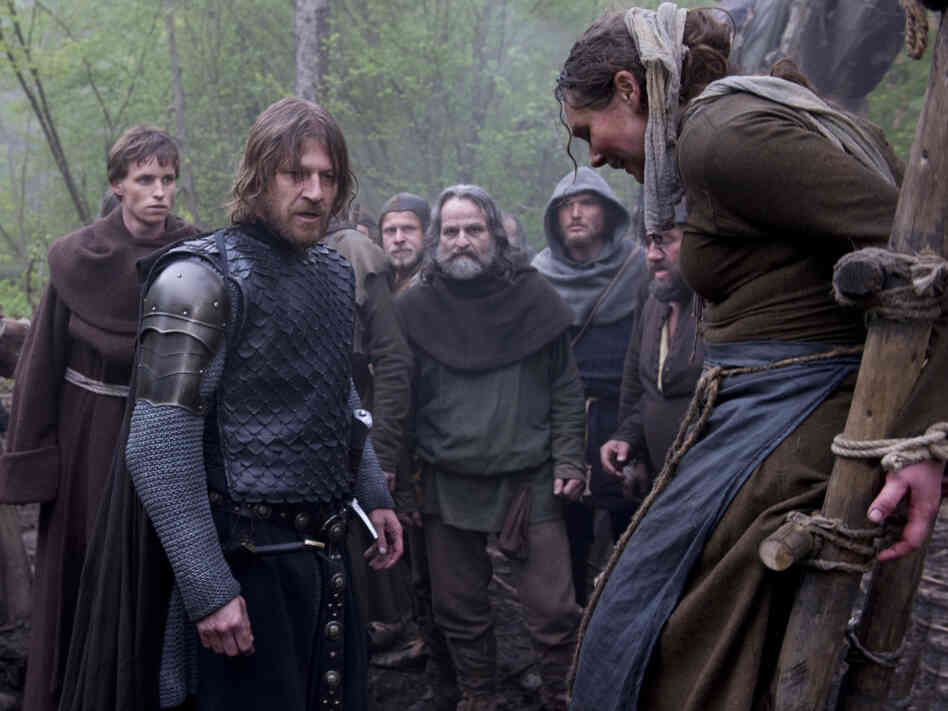 Suffer, Witch: The church, for its part, deploys an enforcer (Sean Bean, center, with Eddie Redmayne, left) who's got decidedly medieval ideas about uppity women.
