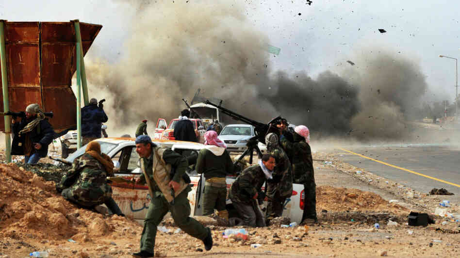 Shrapnel flies through the air as a tank shell explodes near Libyan rebel fighters defending their last position against Gadhafi's loyalist forces at Ras Lanuf on Thursday. Shrapnel flies through the air as a tank shell explodes near Libyan rebel fighters defending their last position against Gadhafi's loyalist forces at Ras Lanuf on Thursday.