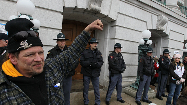 Officers stand in front of a Wisconsin Capitol entrance as they bar entry to the building.