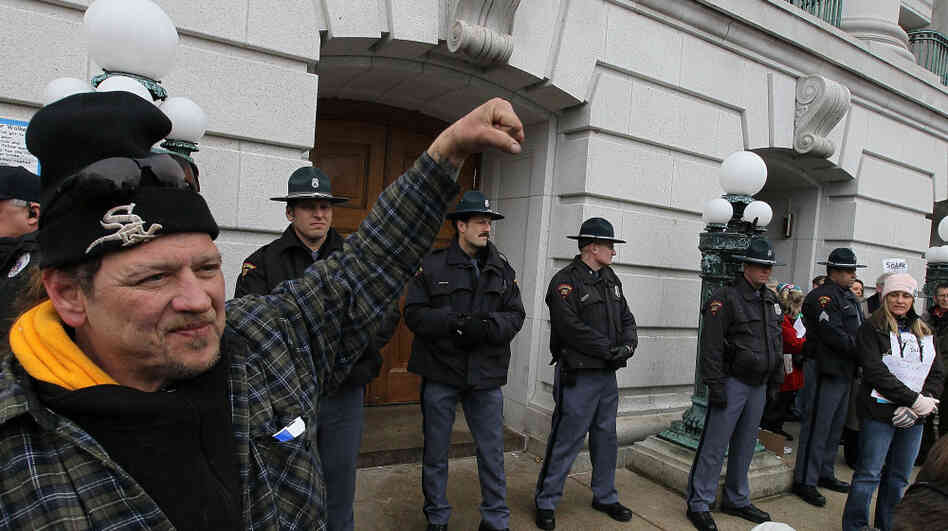 Officers stand in front of a Wisconsin Capitol entrance as they bar entry to the building.