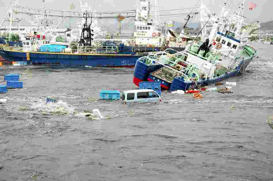 Fishing boats and vehicles are carried by a tsunami wave at Onahama port in Iwaki city, in Fukushima prefecture, northern Japan. 