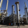 A worker walks in front of a refinery inside the Brega oil complex in Libya. Events in North Africa and the Middle East are being closely watched by oil traders to determine what a barrel is worth.