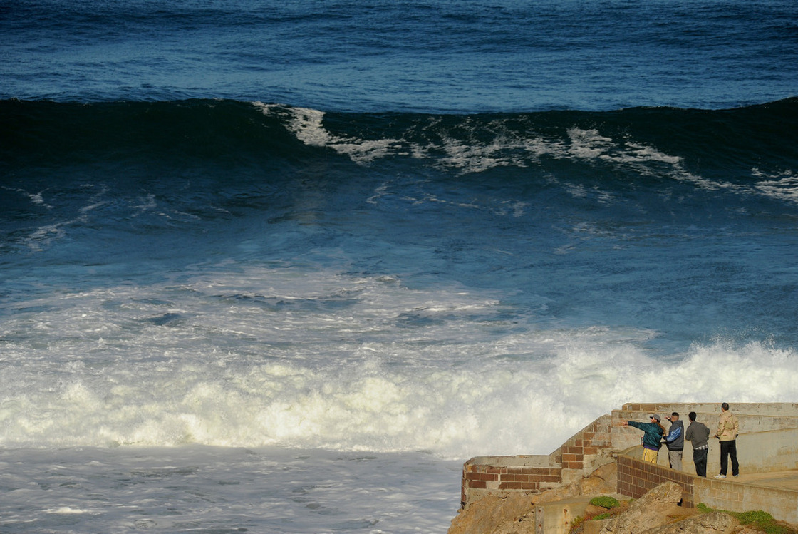 With a tsunami warning in effect for Northern California, sightseers watch waves off Ocean Beach in San Francisco on Friday.
