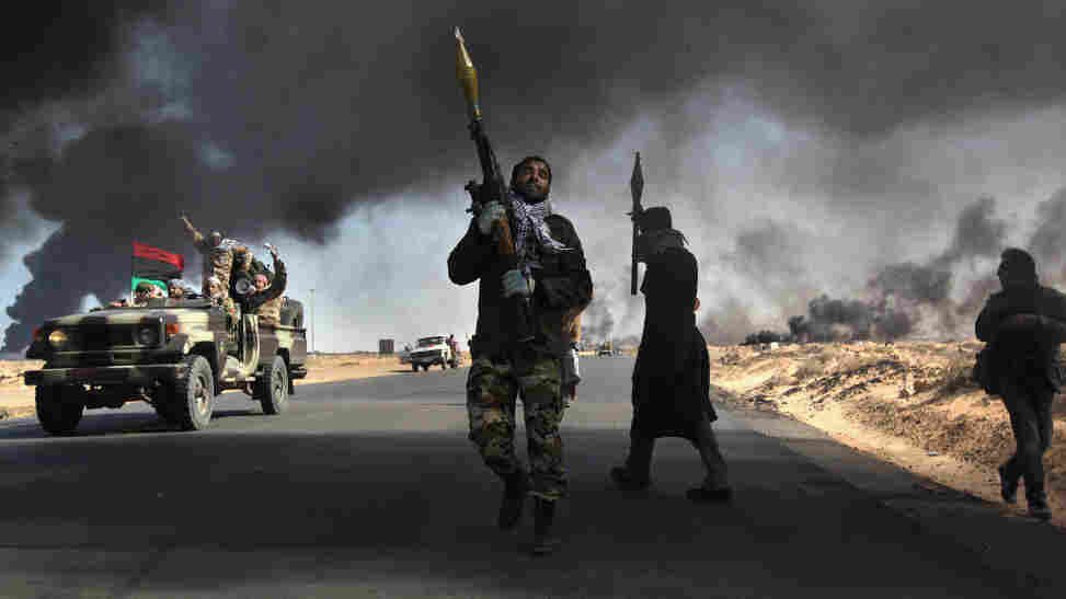 Libyan rebels battle government troops as smoke from a damaged oil facility darkens the front-line sky Friday in Ras Lanuf, Libya. Libyan rebels battle government troops as smoke from a damaged oil facility darkens the front-line sky Friday in Ras Lanuf, Libya.
