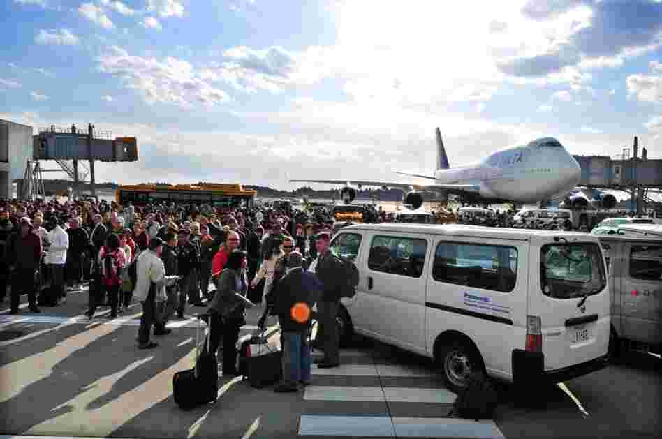 Travelers stand on the tarmac after Narita International Airport in suburban Tokyo was evacuated. 