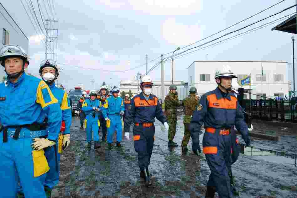 Rescue workers search for missing people in Sendai. Police said between 200 and 300 bodies were found along the coast. 