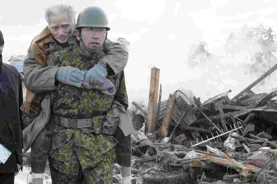 A self-defense force member assists a victim in the city of Natori in northern Japan. 
