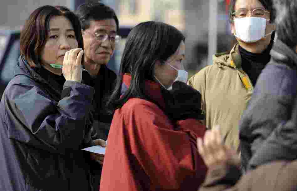 People wait in line for supplies in Fukushima, northern Japan, on Sunday. An explosion at a reactor of the Fukushima nuclear plant triggered fears of a meltdown after a massive earthquake and tsunami hit the country Friday. 