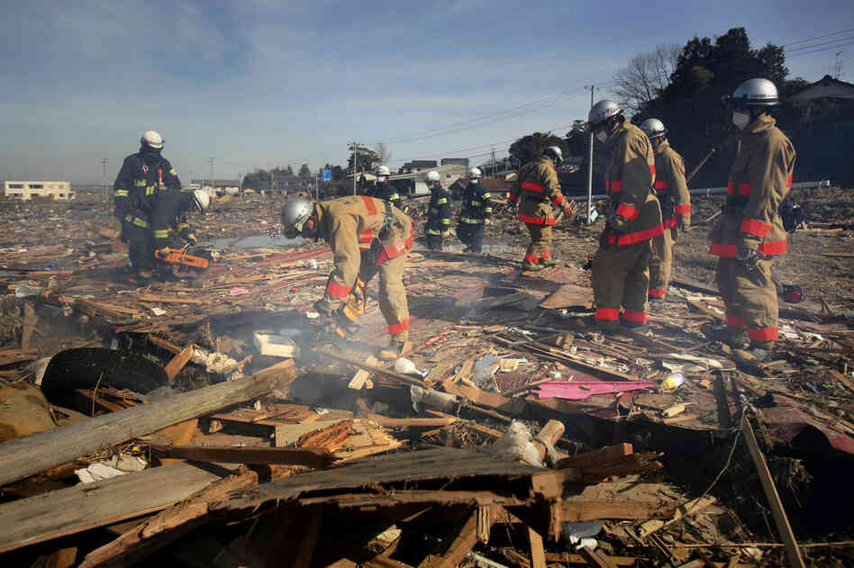 Fire department rescue workers search for victims in the coastal area of Soma city, Fukushima prefecture. 