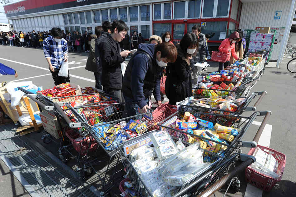Residents queue for supplies in Natori City, Miyagi prefecture. 