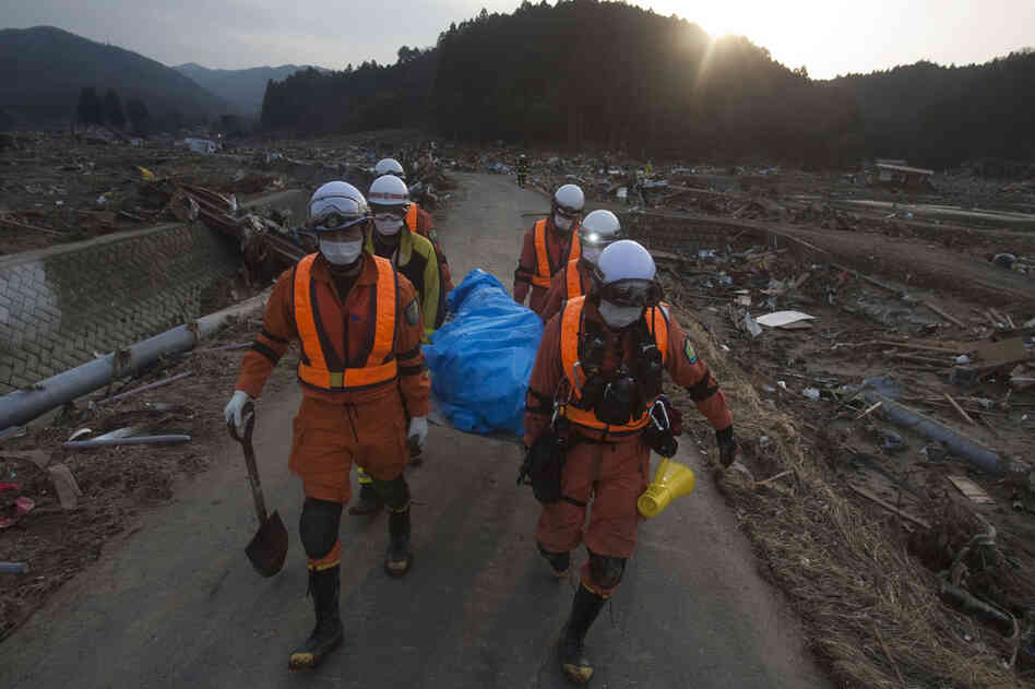 Japanese rescue team members carry a body in the village of Saito, in northeastern Japan. 
