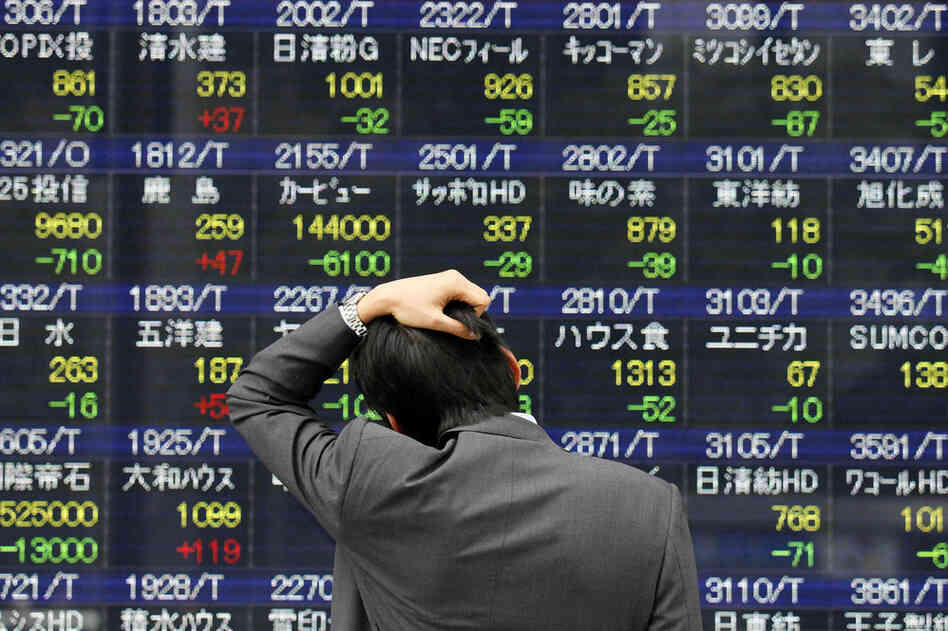 A man examines a stock price board in Tokyo as the market plunges on its first business day after the earthquake and tsunami. 