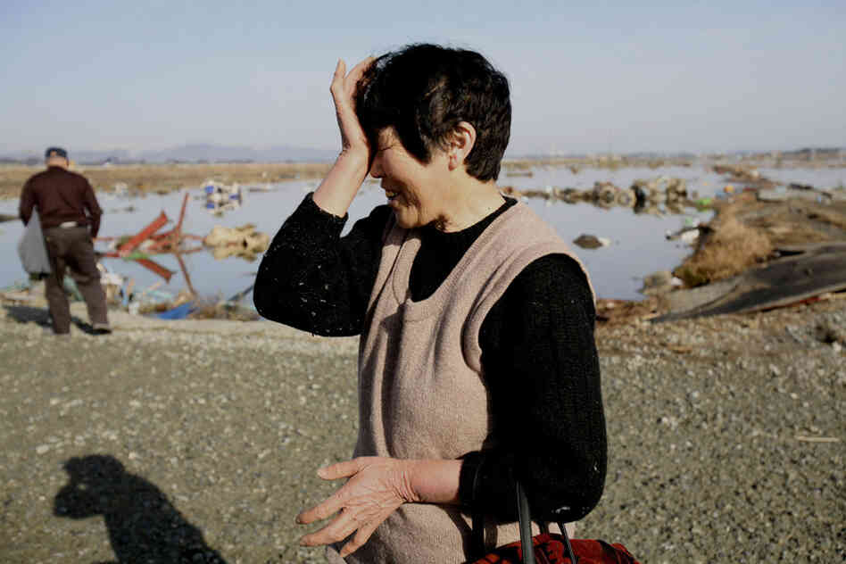 A resident wipes tears as she finds no remains of her home in Soma city, Fukushima prefecture. 