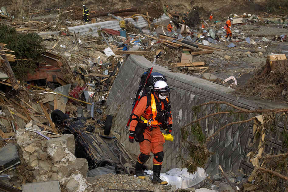A Japanese rescue team member walks through the leveled village of Saito, in northeastern Japan. 