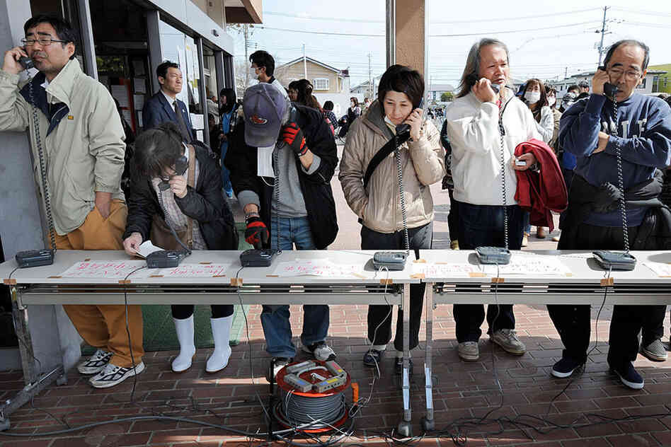 People use temporary phones set up for residents at the Natori City Hall in Natori, Miyagi prefecture on Monday. 