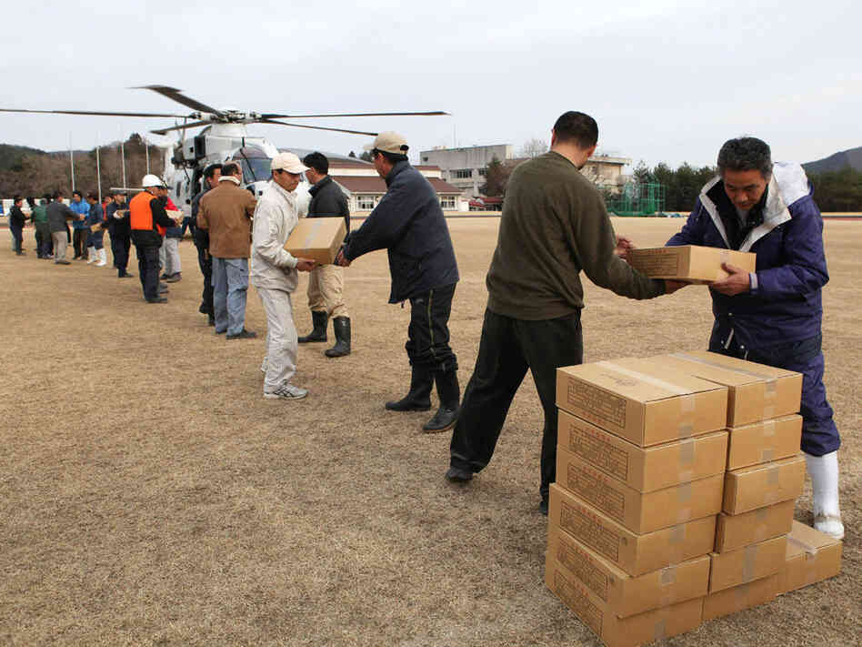 Local residents and town staff carry out relief supplies from a helicopter in the town of Onagawa in Miyagi prefecture on Monday, three days after a massive 8.9 magnitude earthquake and tsunami devastated the coast of eastern Japan. Local residents and town staff carry out relief supplies from a helicopter in the town of Onagawa in Miyagi prefecture on Monday, three days after a massive 8.9 magnitude earthquake and tsunami devastated the coast of eastern Japan.