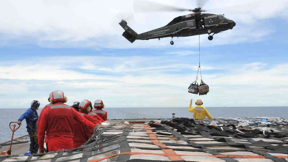 Sailors aboard the U.S. 7th Fleet command ship USS Blue Ridge stand by to move pallets of humanitarian relief supplies across the ship's flight deck. Sailors aboard the U.S. 7th Fleet command ship USS Blue Ridge stand by to move pallets of humanitarian relief supplies across the ship's flight deck.