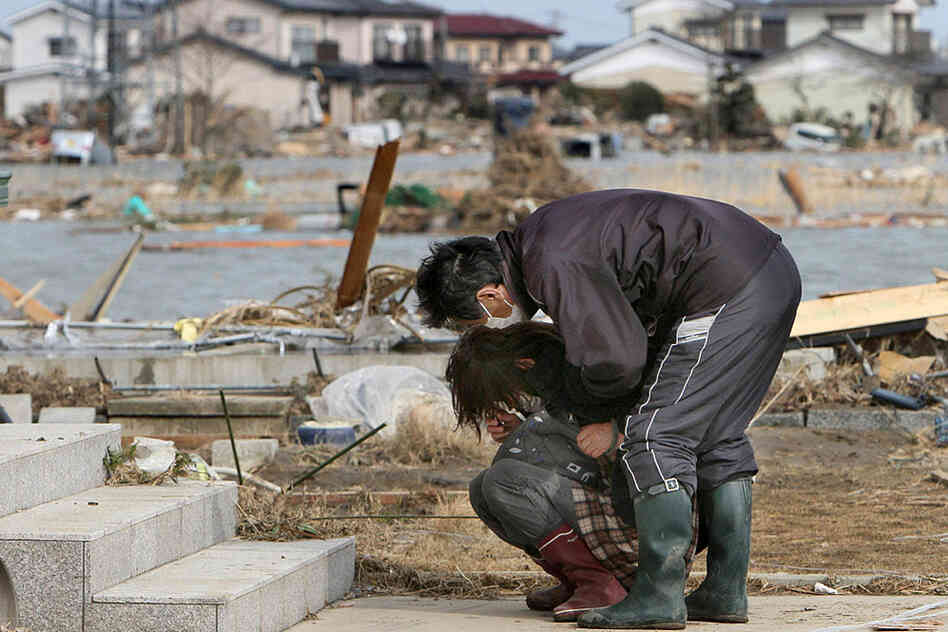 Victims of Japan's earthquake and tsunami mourn a destroyed home in the town of Watari in Miyagi prefecture on Monday. 