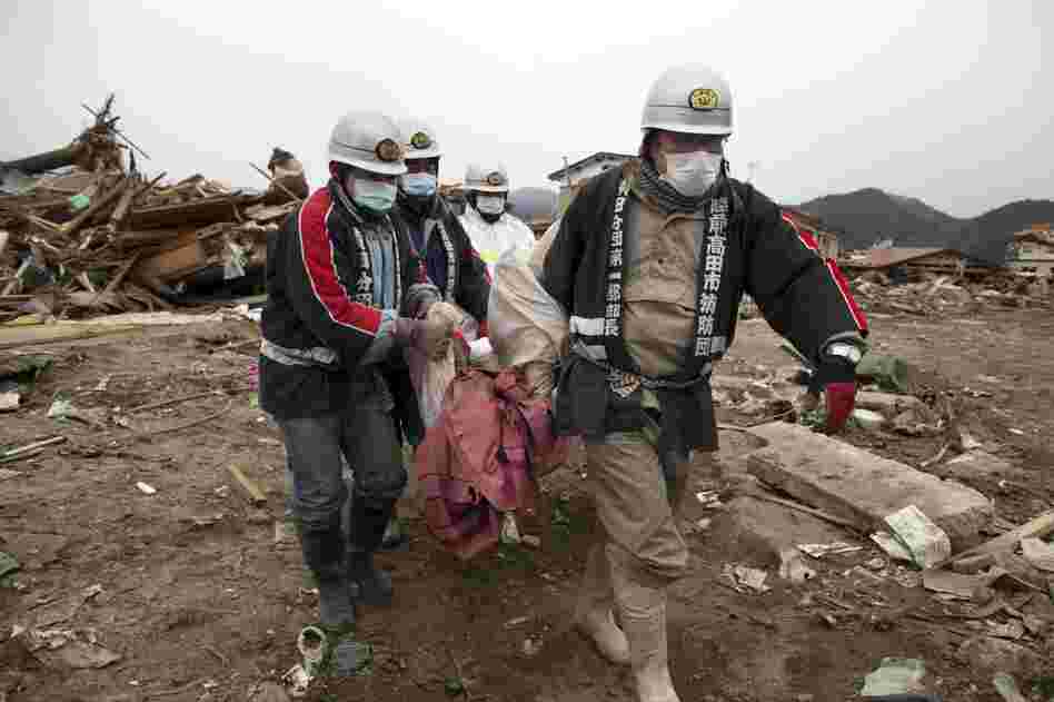 Rescue workers carry a body from the rubble in Rikuzentakata, Iwata prefecture in northeastern Japan on Tuesday. 