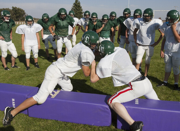 Players for the combined football team of Sandhills High School and Thedford High School train during practice in Dunning, Neb., in 2009.
