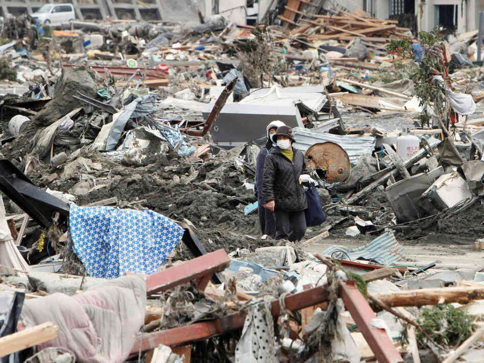 People walked through rubble in Minami-Sanrikucho, Miyagi prefecture, earlier today (March 15, 2011).