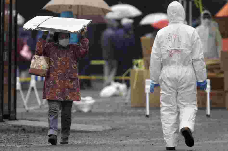 A woman carrying a heat blanket leaves a radiation emergency scanning center in Koriyama in Japan. 