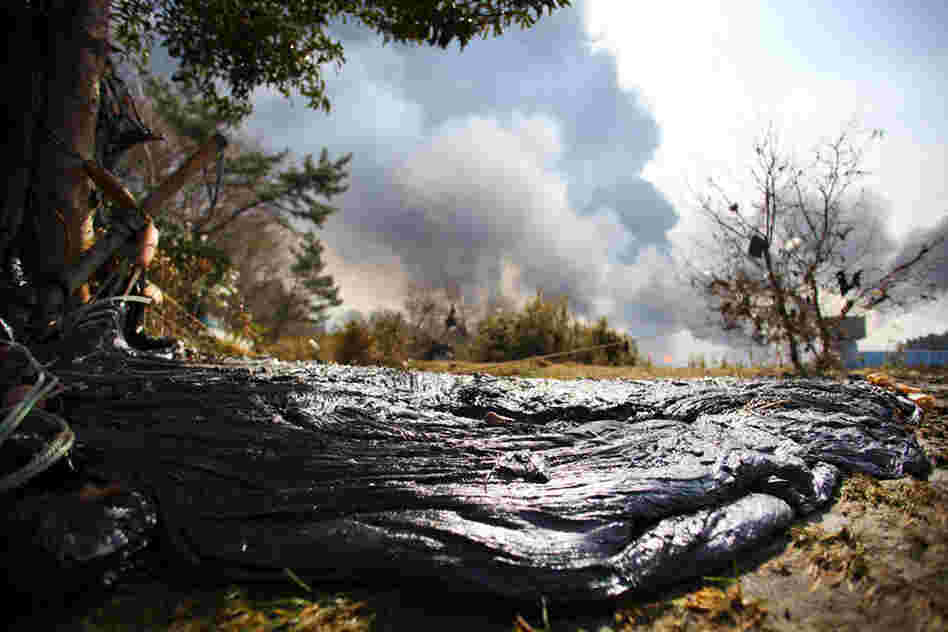 Tar from a burning oil refinery lies on a river bed near Sendai, northern Japan. 