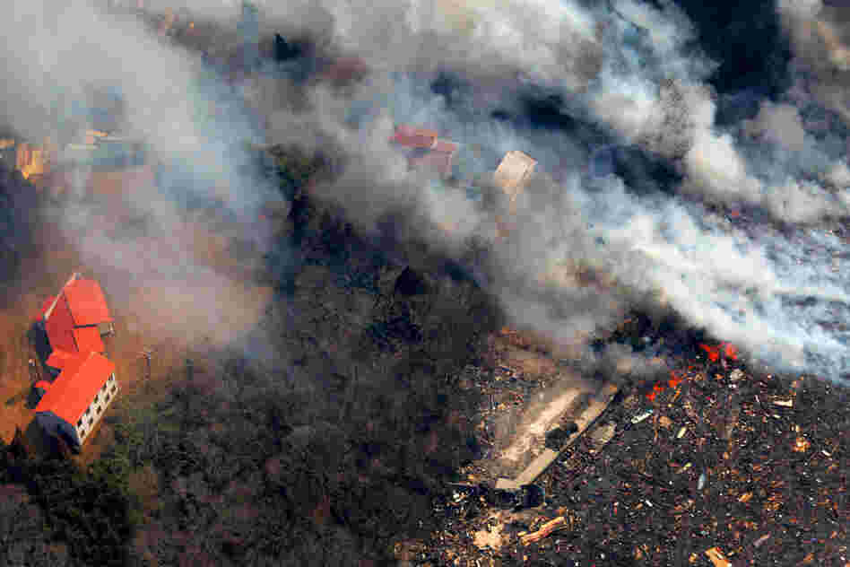 Smoke rises from burning debris washed away by tsunami waters in Kesennuma, Miyagi prefecture, on Sunday, two days after Japan's biggest recorded earthquake. 