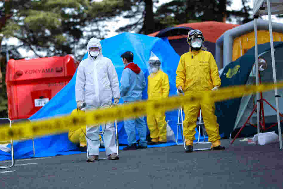 Fire department officials wait for arriving residents evacuated from areas surrounding the nuclear facilities 170 miles north of Tokyo . 