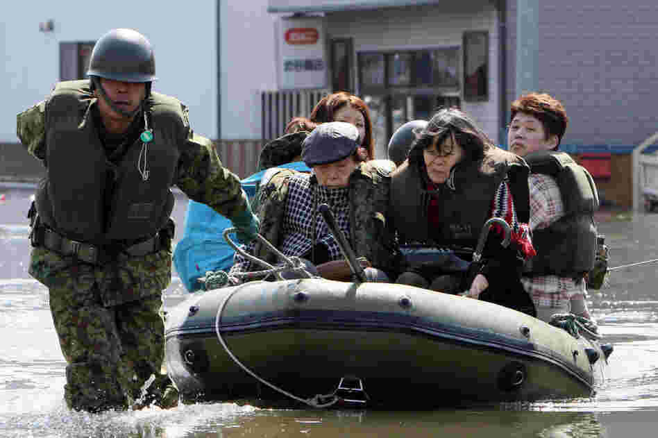 A soldier pulls evacuated people in a rubber boat at Ishinomaki city in Miyagi prefecture. 