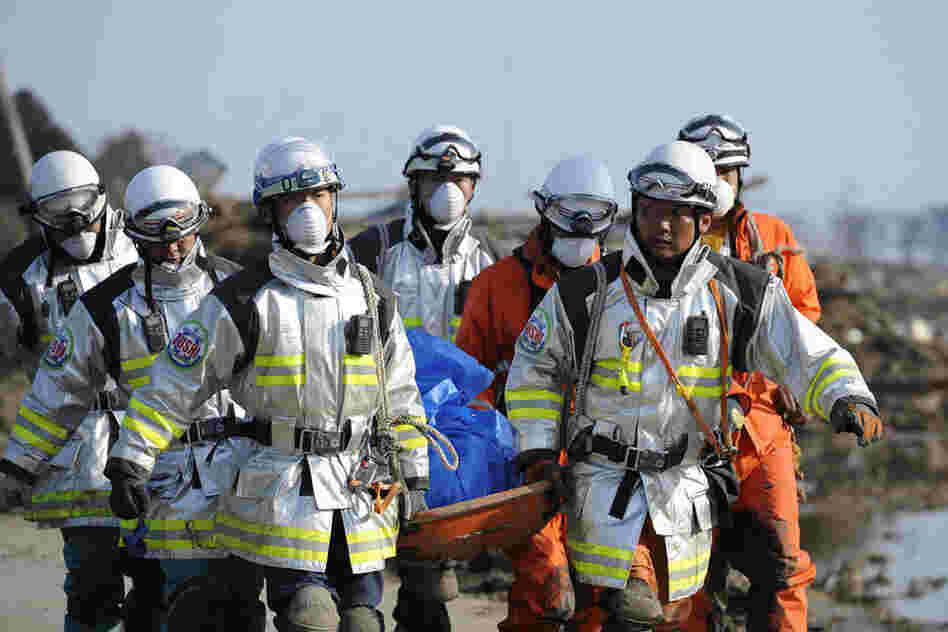 Japanese rescuers carry a body in Sendai. 