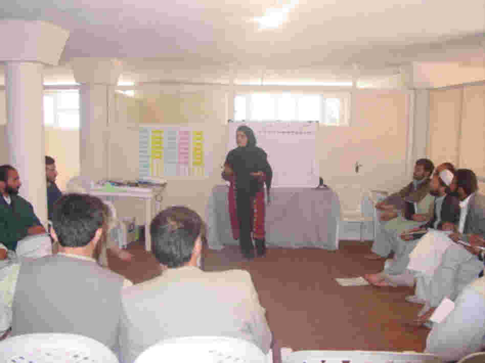 Kamila in the field speaking to groups of men about entrepreneurship. Courtesy of Mercy Corps.