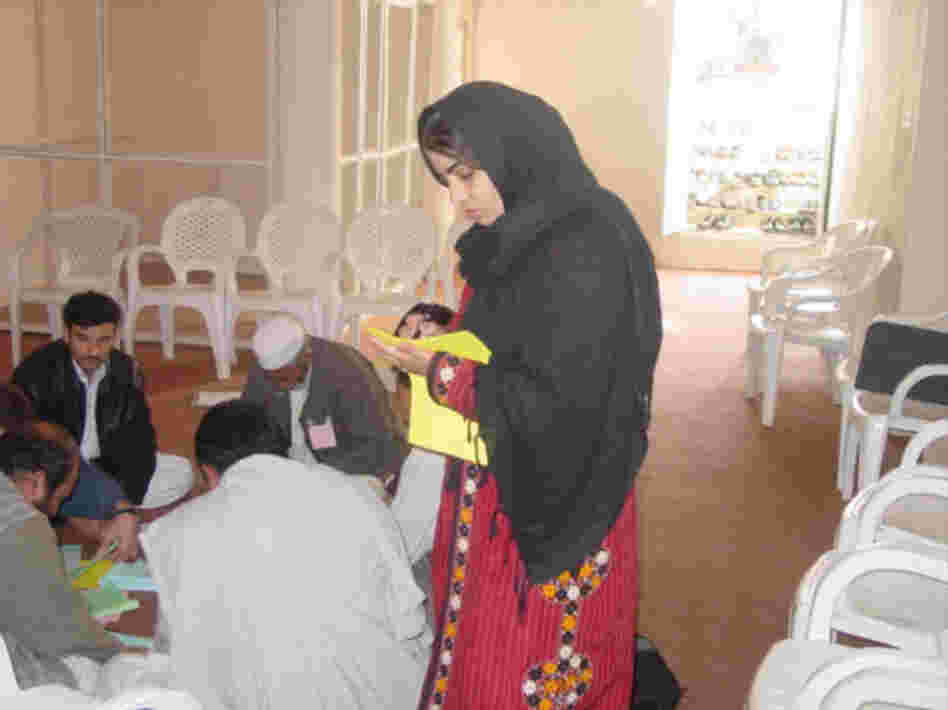 Kamila in the field speaking to groups of men about entrepreneurship. Courtesy of Mercy Corps.