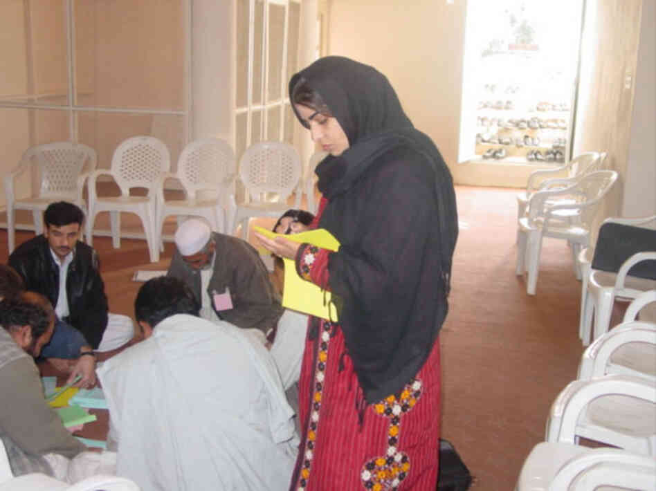 Kamila in the field speaking to groups of men about entrepreneurship. Courtesy of Mercy Corps.