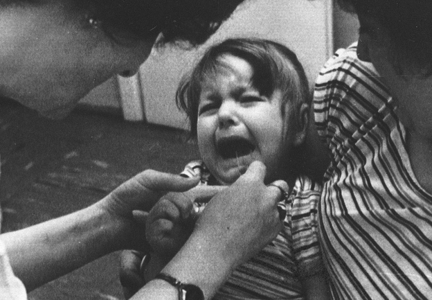 A nurse at a children's health clinic in Warsaw administers an iodine solution to a 3-year-old girl held in her mother's arms in Poland, May 1986, as a protective measure against possible radiation poisoning after the Chernobyl disaster.