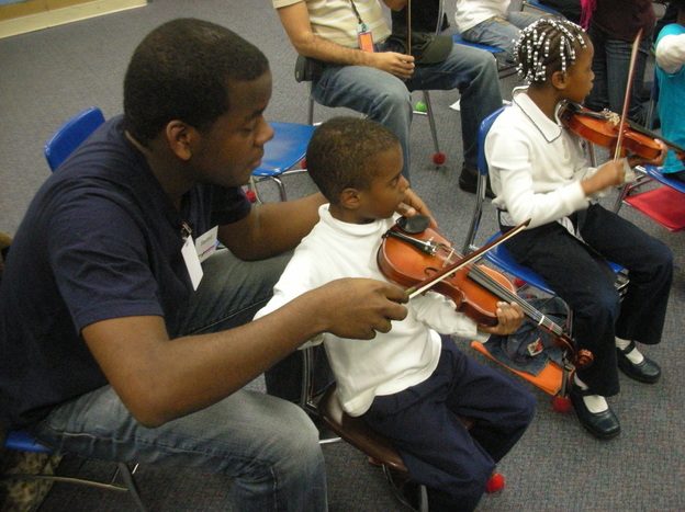 Stanford Thompson, another Abreu Fellow alum, adjusts a student's bowing in a nucleo in Philadelphia.