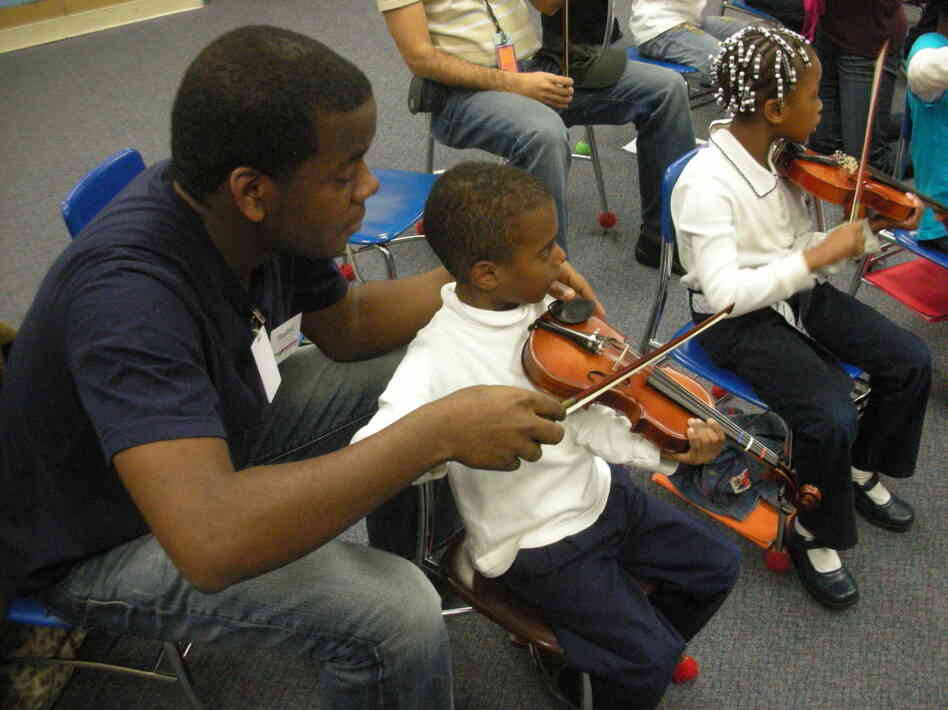 Stanford Thompson, another Abreu Fellow alum, adjusts a student's bowing in a nucleo in Philadelphia.