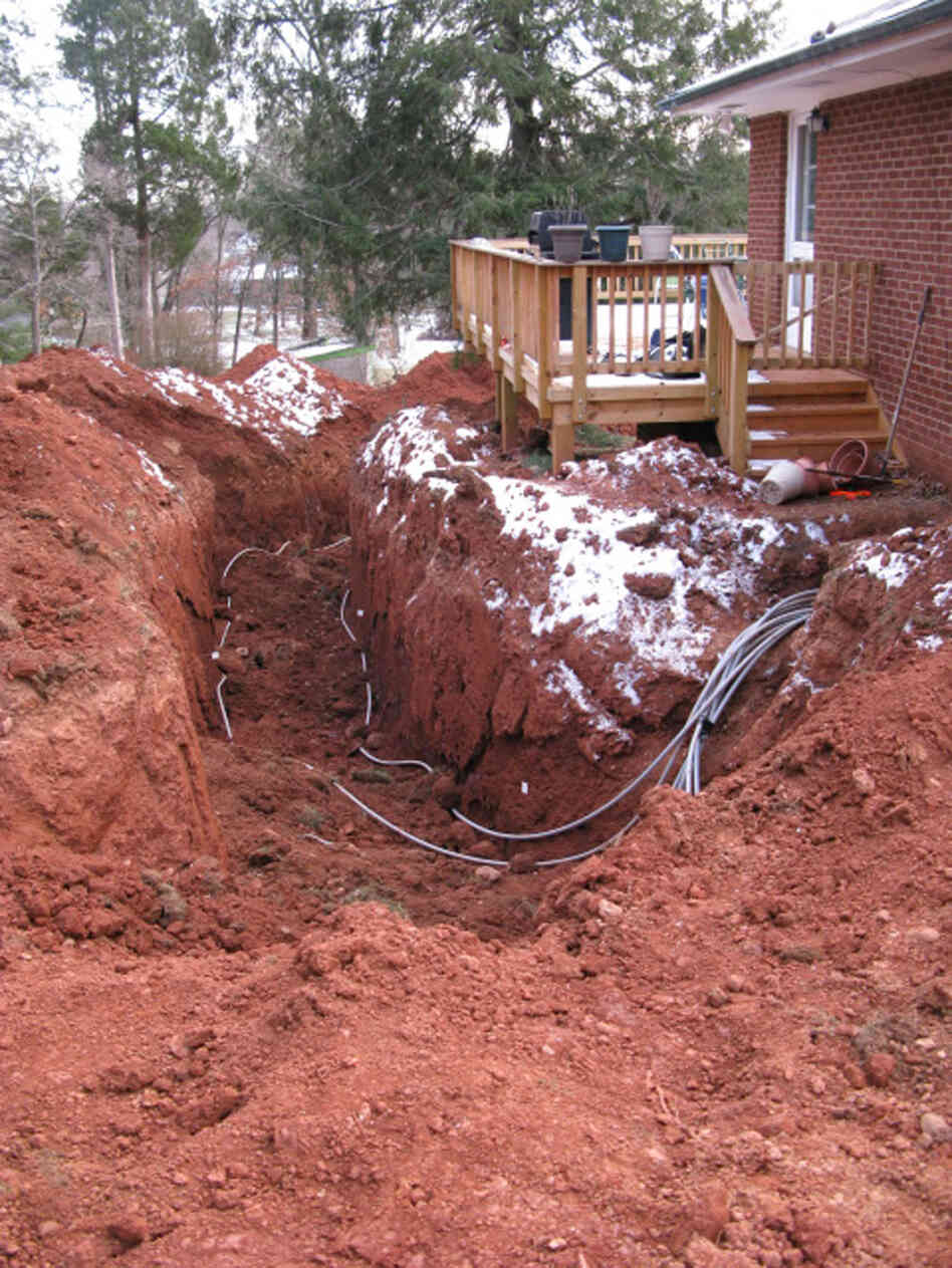 Homeowners Suzi and James Bryant opted to install a geothermal system. To save some money, they rented a backhoe and dug a deep ditch in their side yard for the project. Homeowners Suzi and James Bryant opted to install a geothermal system. To save some money, they rented a backhoe and dug a deep ditch in their side yard for the project.