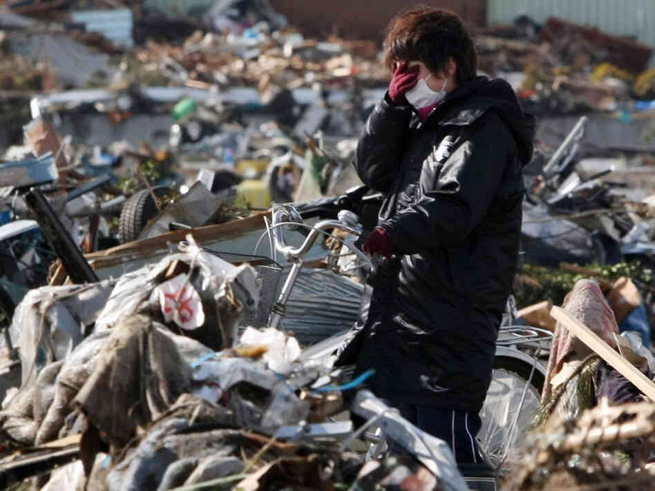 A woman reacts in the debris after her house was totally destroyed by the recent tsunami at Sendai in Miyagi prefecture on March 16, 2011. A woman reacts in the debris after her house was totally destroyed by the recent tsunami at Sendai in Miyagi prefecture on March 16, 2011.