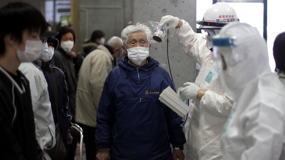 A man is scanned for radiation exposure at a temporary center for residents living close to the damaged Fukushima Daiichi plant on Wednesday, March 16, 2011.