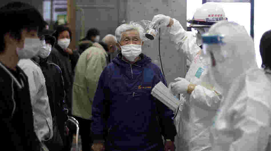 A man is scanned for radiation exposure at a temporary center for residents living close to the damaged Fukushima Daiichi plant on Wednesday, March 16, 2011.