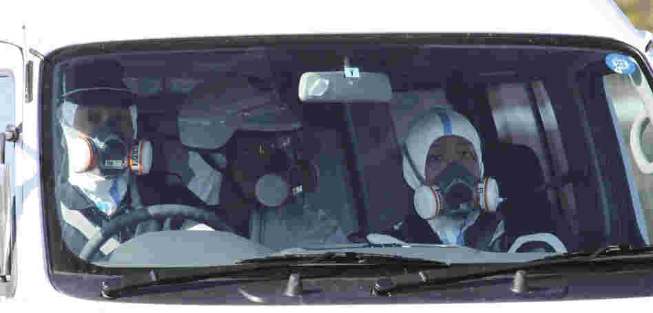 Police officers wear gas masks while on patrol in a vehicle at the Fukushima nuclear power plant on March 12. Experts are concerned about the safety of the nuclear workers, but they say that so far, there's no risk for others in Japan or in the U.S.