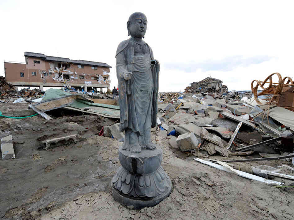 A religious statue stands amid the debris left by last Friday's tsunami in Natori, Miyagi prefecture. Many Japanese will turn to Shinto and Buddhist rituals as they cope with the disaster stemming from a powerful earthquake.