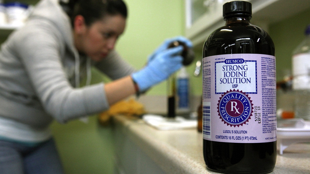 A worker at West Marin Pharmacy, Point Reyes, Calif., fills vials with strong iodine solution on Tuesday.